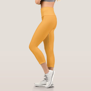 a yellow background with a black border capri leggings