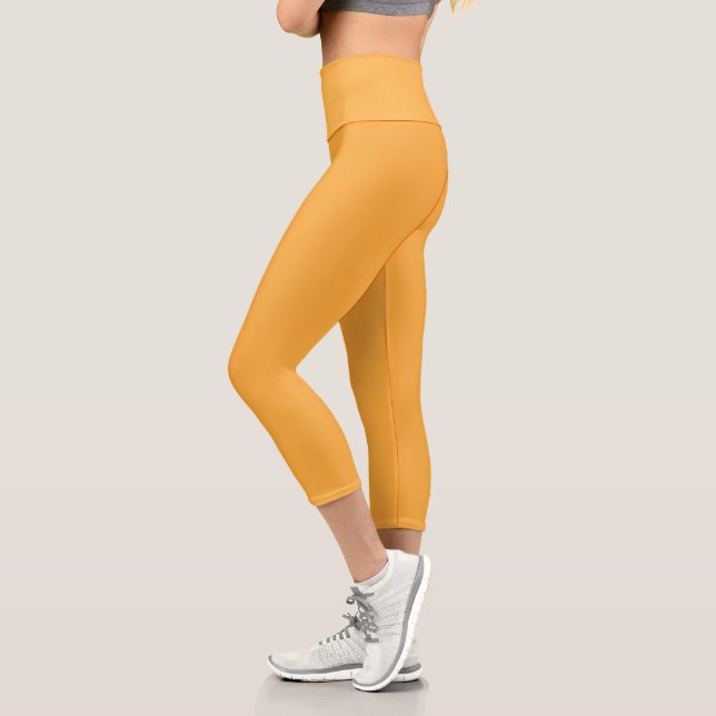 a yellow background with a black border capri leggings (Left)