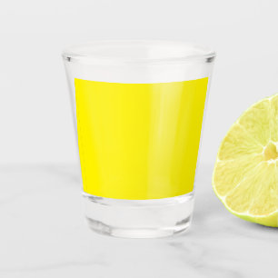 a yellow background with a black border shot glass