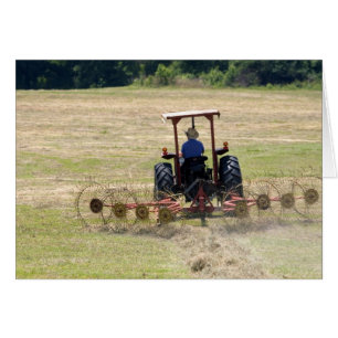 A young boy driving a tractor harvesting