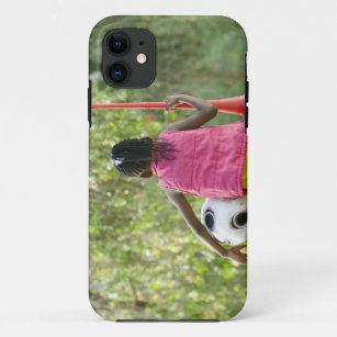 A young girl sits on a bench, holding a Vuvuzela iPhone 11 Case