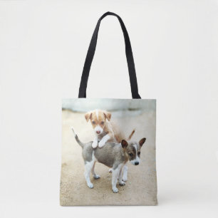 Adorable Puppies Playing on Beach Tote Bag