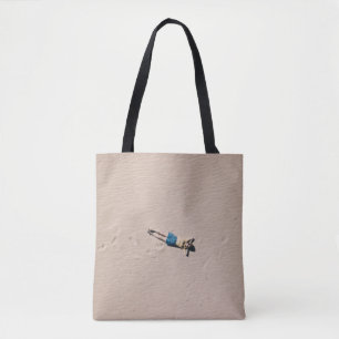 Aerial photograph of man lying on sand tote bag