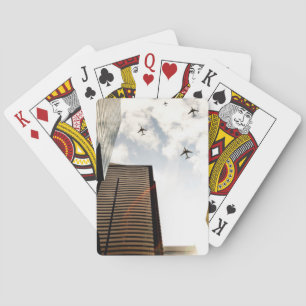 Aeroplanes flying over buildings playing cards