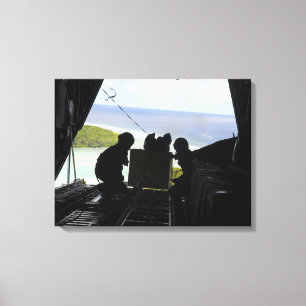Airmen push out a pallet of donated goods canvas print
