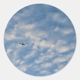 Airplane Crossing a Cloud-Filled Blue Sky Classic Round Sticker