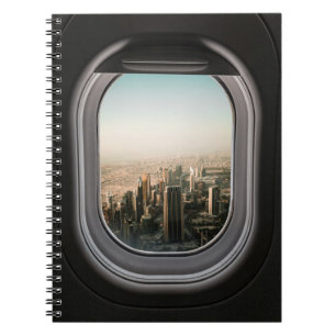 AIRPLANE WINDOW VIEW OF CITY DURING DAYTIME NOTEBOOK