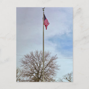 American flag on a flag pole flying high. holiday postcard
