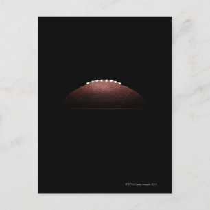 American football ball on black background postcard