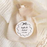 Amour | Illustrated French Bow Wedding Classic Round Sticker<br><div class="desc">This chic and elegant wedding favour sticker features a hand drawn,  wavy illustrated frame with a bow,  and stylish handwritten script for a Parisian or French style wedding invitation. This classic colour option is ivory and black.</div>