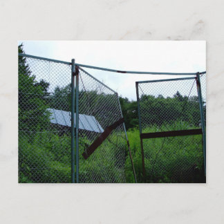 An abandoned house beyond the broken fence. postcard