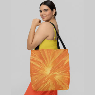 An abstract orange and yellow radial pattern tote bag