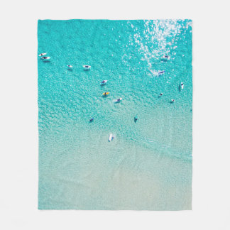 An aerial view of surfers waiting for a wave in th fleece blanket