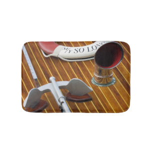 An Anchor And A Life-Buoy On A Wooden Boat Bath Mat