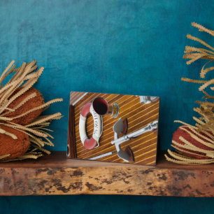 An Anchor And A Life-Buoy On A Wooden Boat Plaque