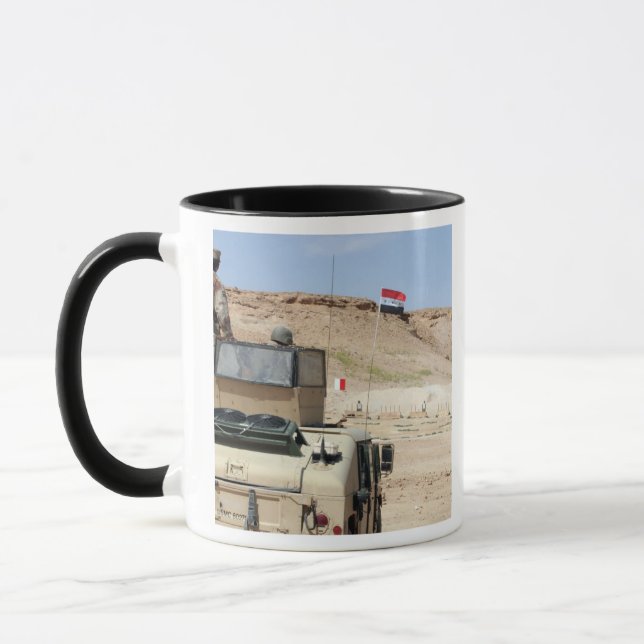 An instructor watches as an Iraqi army soldier Mug (Left)