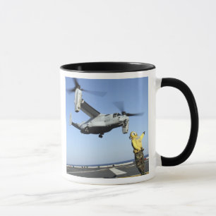 An MV-22 Osprey launches from the USS Nassau Mug