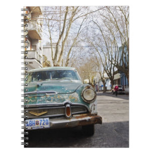 An old car rusty and flaky colour parked in the notebook