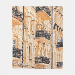 An old yellow house with wrought-iron balconies. f fleece blanket