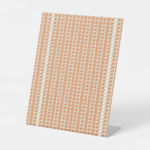 an orange and white striped background with small pedestal sign