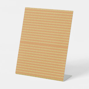 an orange and yellow background with small dots pedestal sign