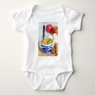 Applesauce with cinnamon in stoneware bowl baby bodysuit