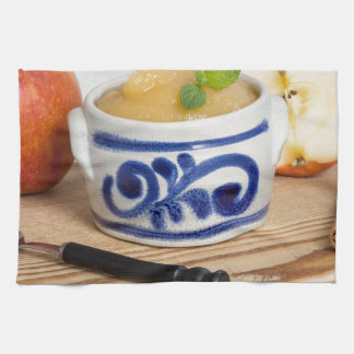 Applesauce with cinnamon in stoneware bowl tea towel