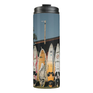 Assorted surfing boards stands on open field in th thermal tumbler