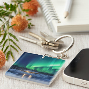 Aurora borealis over winter cabin key ring