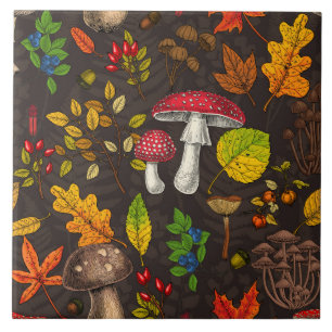 Autumn mushrooms, leaves, nuts and berries on dark ceramic tile