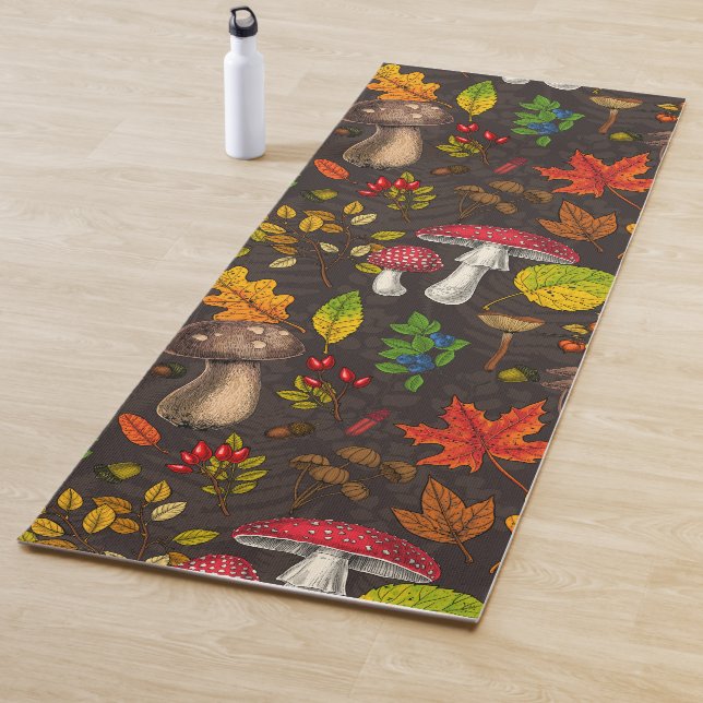 Autumn mushrooms, leaves, nuts and berries on dark yoga mat (In Situ)