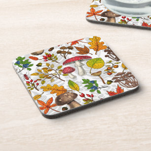 Autumn mushrooms, leaves, nuts and berries on whit coaster