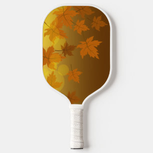 Autumn pattern with falling maple leaves and bokeh pickleball paddle