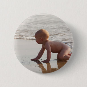 Baby playing in the sand on the beach 6 cm round badge