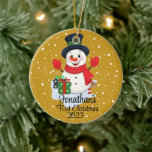 Baby's First Christmas cute snowman black hat  Ceramic Ornament<br><div class="desc">A whimsical Christmas tree ornament featuring an adorable snowman surrounded by delicate snowflakes. Customise it with your child's name and the year for a personalised touch that captures the joy of the season.
Use the "Personalise" button to customise to your liking.</div>