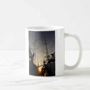 Backlight on 2 sailboats in the harbor. coffee mug