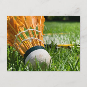 Badminton racket on green grass on a sunny day postcard