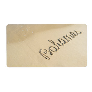 Bahamas carved sign on the beach sand