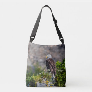 Bald eagle sitting on the rock crossbody bag