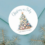 Beach Christmas In July Classic Round Sticker<br><div class="desc">Celebrate in sunny style with this festive round sticker, perfect for your Christmas in July celebration. A large Christmas tree made of beach shells, starfish, and coral sits in the centre, bringing a fun and whimsical coastal vibe to your event. The design features a teal blue and tan colour palette...</div>