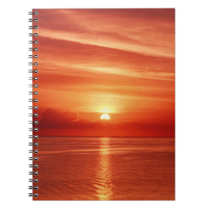 Beautiful colourful sunrise at the sea with dramat notebook