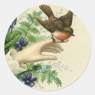 Beautiful hand with a bird and flowers classic round sticker