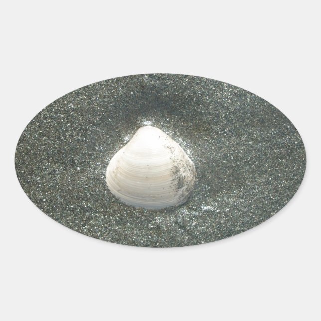 Beautiful Seashell in the Sand: A Salty Souvenir Oval Sticker (Front)