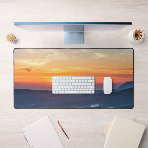 Beautiful sunset behind green fields desk mat