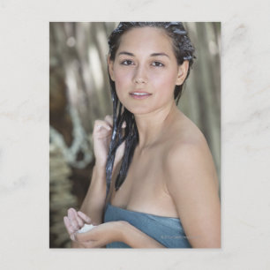 Beautiful young woman wrapped in towel and postcard