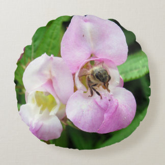 Bee emerging from a sweet pea flower round cushion