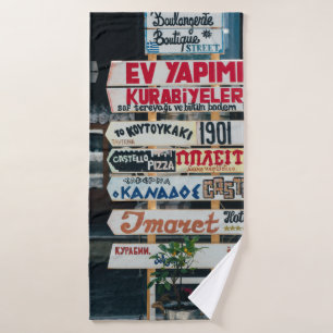BEIGE RED AND BROWN SIGNAGES ON BEIGE STAND AT DAY BATH TOWEL