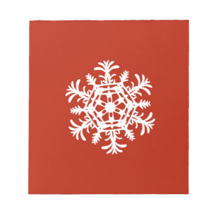 Big white snowflake on red notepad