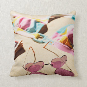 Bikini Top And Heart Shape Sunglasses On Beach Cushion
