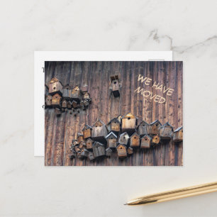 Bird house on a wooden wall, fun we haved moved  postcard